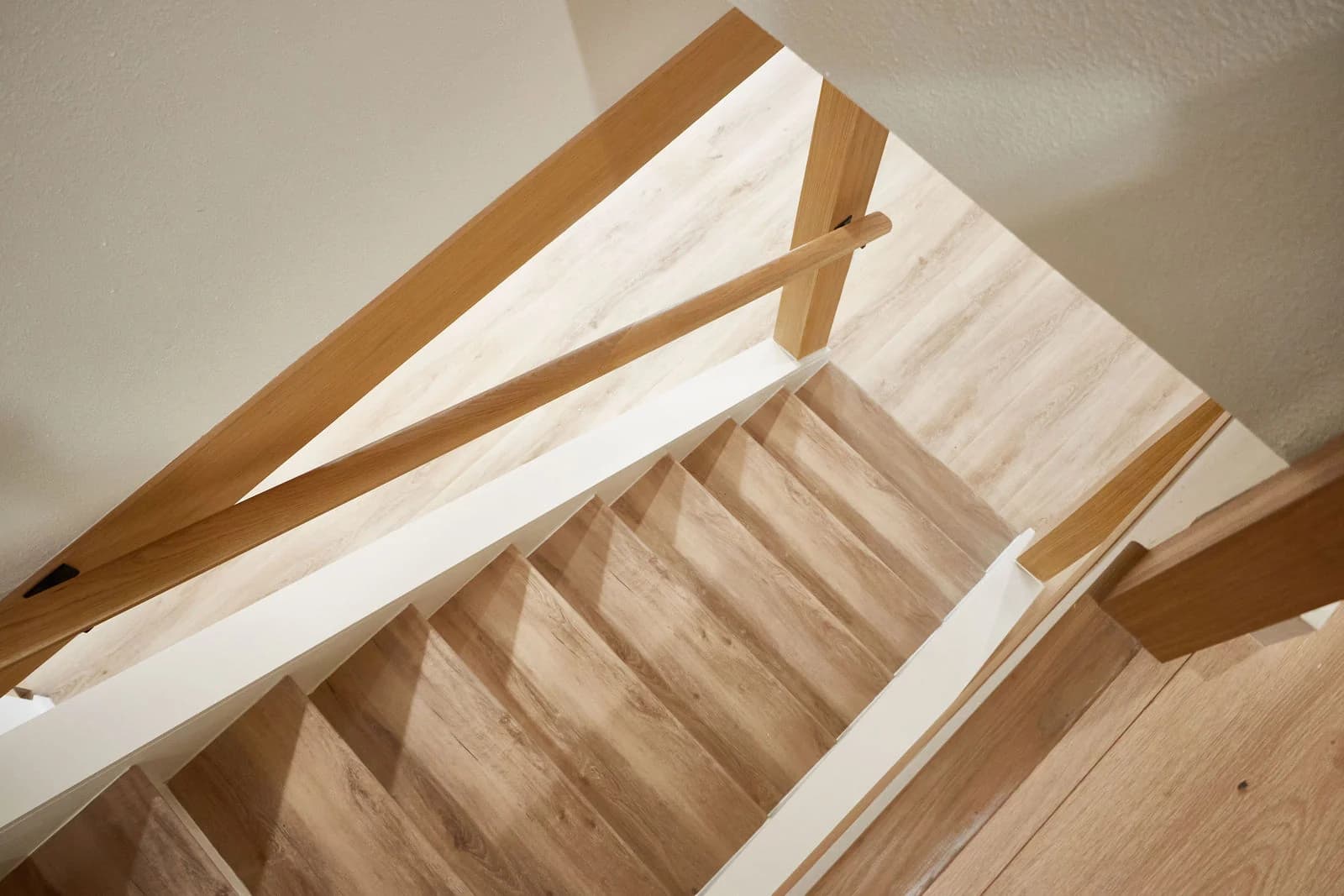 White oak stair treads and a matching wood railing seen from above. Bellevue, WA
